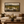 Lowland framed wall art hanging above a sofa in a living room